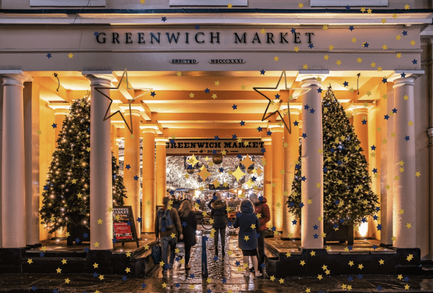 Best London Christmas Markets 2025 Greenwich Market with Christmas trees at the entrance and golden decoration theme.